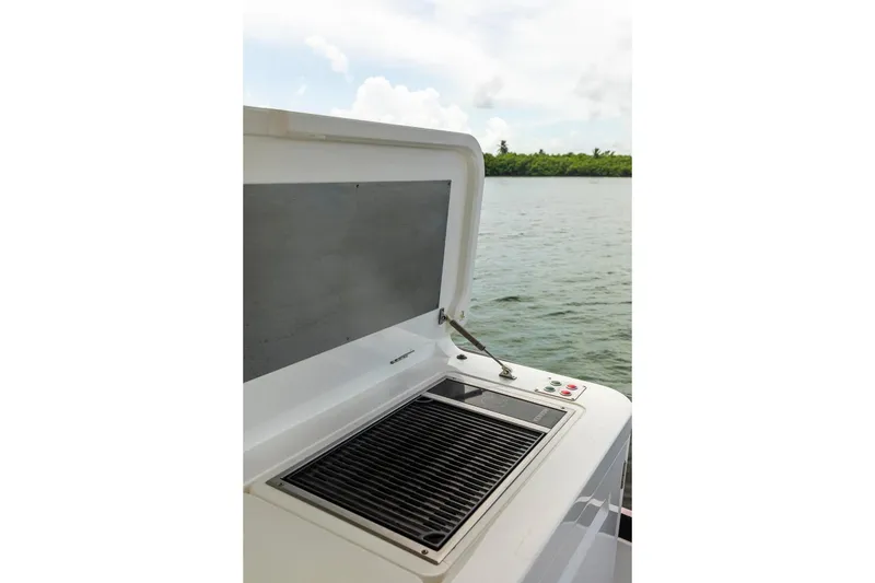 Slide: The Image of Outdoor grill on 2021 Sunseeker Manhattan 68 yacht, overlooking serene water and lush shoreline. - 75