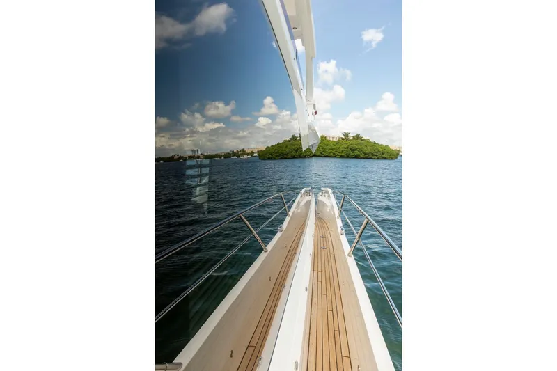 Slide: The Image of 2021 Sunseeker Manhattan 68 yacht cruising on blue water with island view. - 92