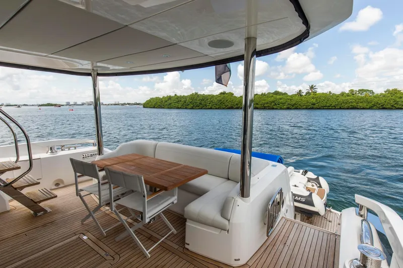 Slide: The Image of Luxury Sunseeker Manhattan 68 yacht deck with seating, overlooking serene water and lush greenery. - 95