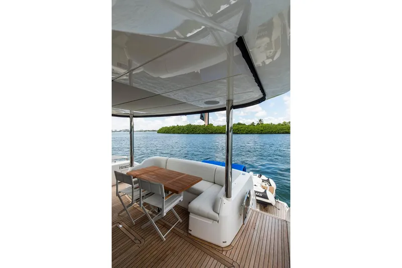 Slide: The Image of Luxurious Sunseeker Manhattan 68 yacht deck with seating, table, and scenic water view. - 96