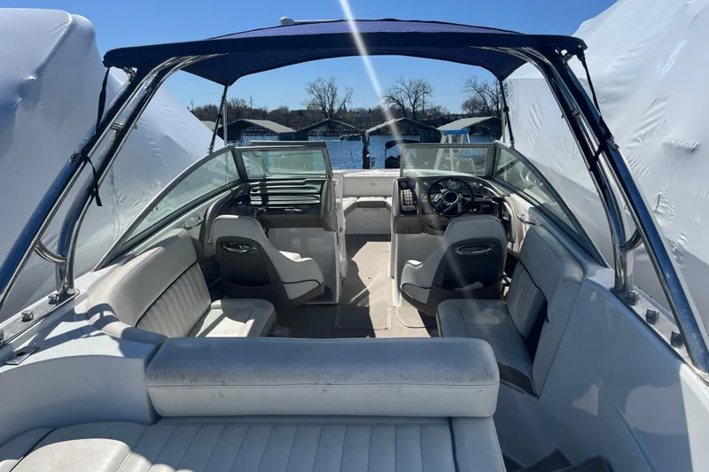 Slide: The Image of 2006 Cobalt 272 boat interior with seating and steering wheel, docked near water. - 13