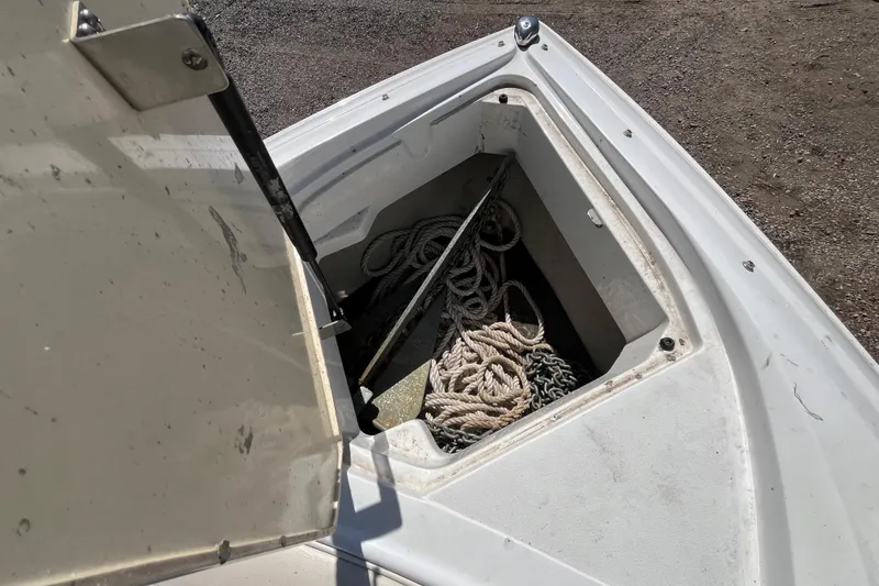 Slide: The Image of Open anchor compartment on a 2006 Cobalt 272 boat, containing ropes and chains. - 26