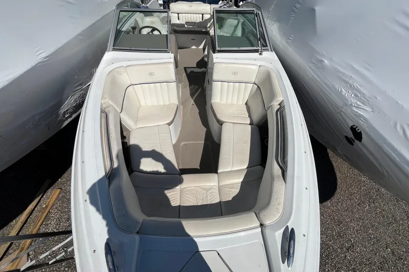 Slide: The Image of 2006 Cobalt 272 boat with white interior seating, parked between covered boats. - 27