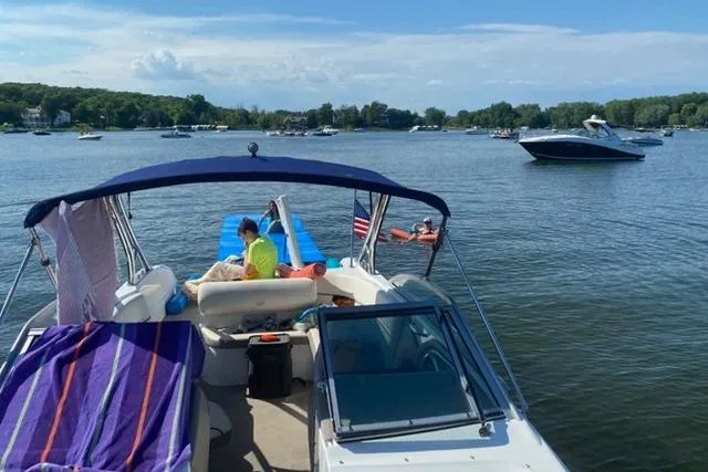Slide: The Image of 2006 Cobalt 272 boat on a lake with people relaxing under a blue canopy. - 3
