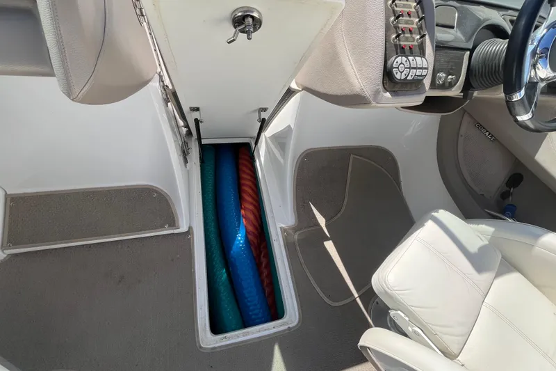 Slide: The Image of Interior of a 2006 Cobalt 272 boat showing storage compartment with colorful pool noodles. - 32