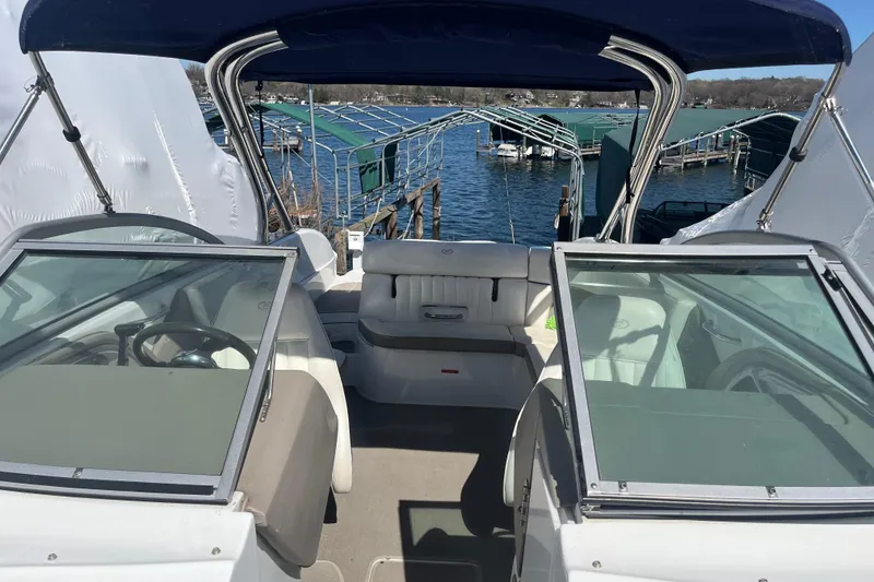 Slide: The Image of 2006 Cobalt 272 boat interior with seating, docked by a lake under a blue canopy. - 36