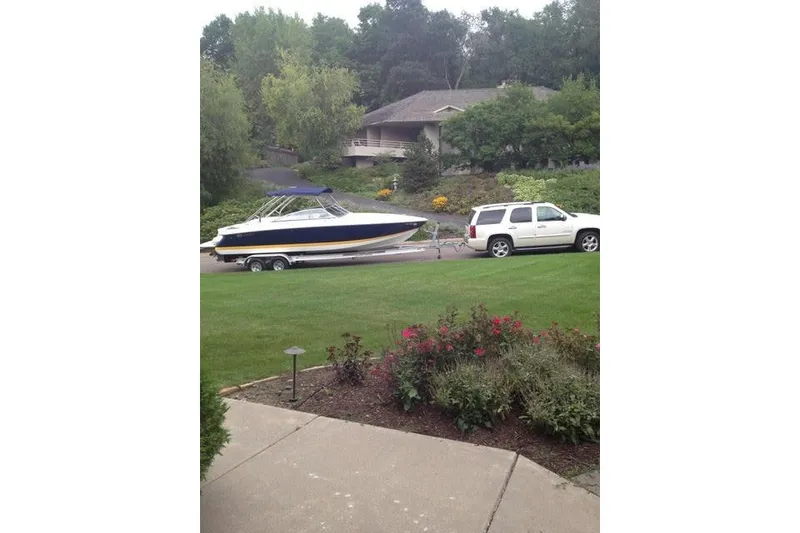 Slide: The Image of White SUV towing a 2006 Cobalt 272 boat on a trailer in a suburban driveway. - 5