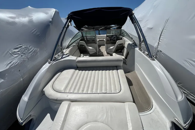 Slide: The Image of 2006 Cobalt 272 boat interior with white seating and canopy, docked under cover. - 8