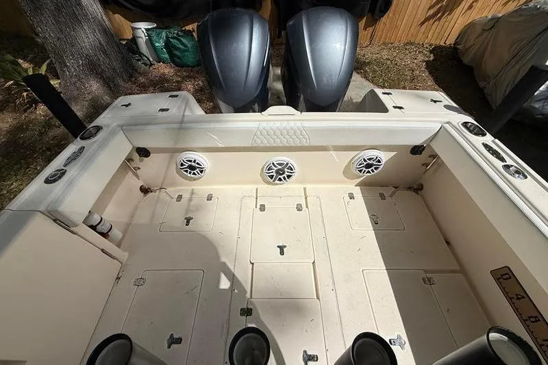 Slide: The Image of 2003 Intrepid 289 Center Console boat deck with speakers and dual engines. - 10