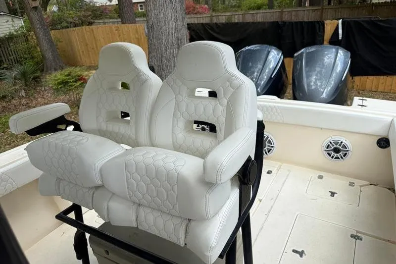 Slide: The Image of 2003 Intrepid 289 Center Console boat with white cushioned seats and dual outboard motors. - 12