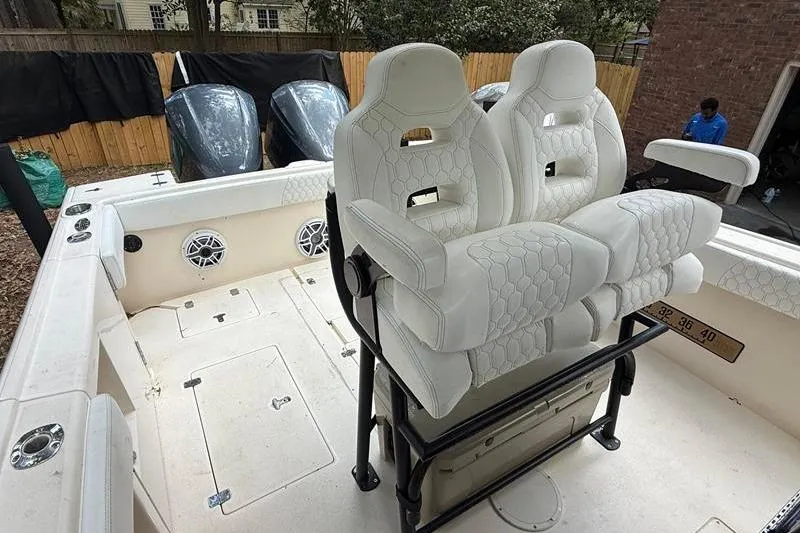 Slide: The Image of 2003 Intrepid 289 Center Console boat with white cushioned seating and dual outboard motors. - 13