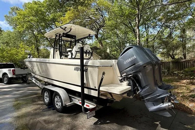 Slide: The Image of 2003 Intrepid 289 Center Console boat on trailer with Yamaha outboard motor in wooded area. - 2
