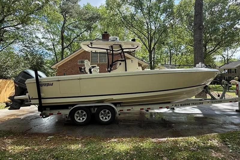 Slide: The Image of 2003 Intrepid 289 Center Console boat on trailer, parked in a residential driveway. - 5