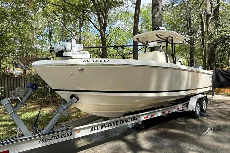 Slide: The Image of 2003 Intrepid 289 Center Console boat on trailer in wooded area. - 7