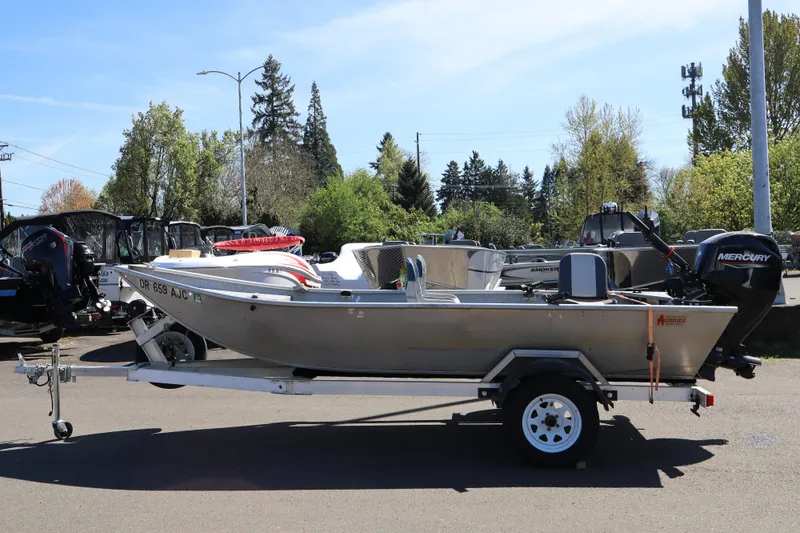 Slide: The Image of 1978 Alumaweld Flatbottom boat on trailer with Mercury outboard motor, parked outdoors. - 15