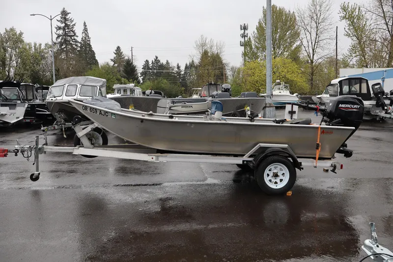 Slide: The Image of 1978 Alumaweld Flatbottom boat on trailer, parked in a lot with other boats. - 3