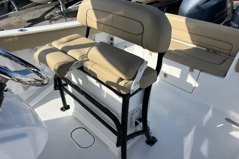 Slide: The Image of 2017 Sportsman Heritage 251 Center Console boat interior with beige seating and steering wheel. - 11