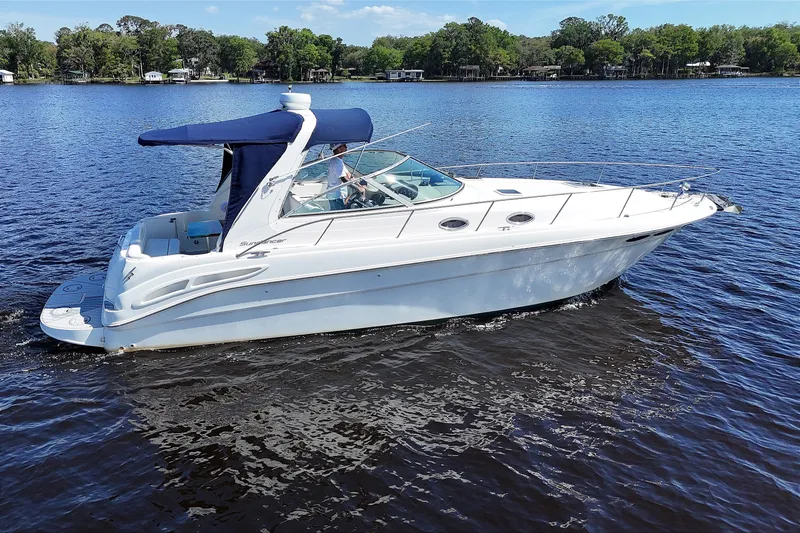 The Image of 2001 Sea Ray 340 Sundancer cruising on a serene lake under a clear blue sky. - 0