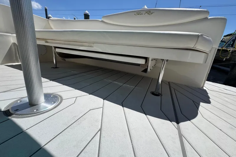 Slide: The Image of 2001 Sea Ray 340 Sundancer boat deck with white seating and metal support pole. - 12