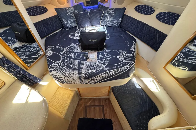Slide: The Image of Interior of 2001 Sea Ray 340 Sundancer with nautical-themed bedding and cozy seating. - 25