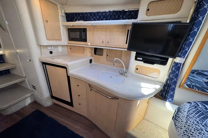 Slide: The Image of 2001 Sea Ray 340 Sundancer interior with kitchenette, microwave, and TV. - 26