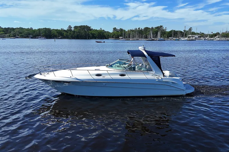 Slide: The Image of 2001 Sea Ray 340 Sundancer cruising on a serene lake under a clear blue sky. - 3