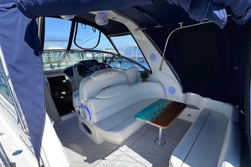 Slide: The Image of Interior of 2001 Sea Ray 340 Sundancer yacht with seating and table, featuring blue accents. - 7