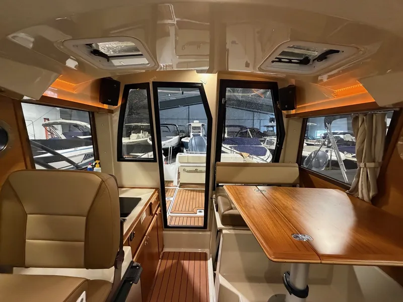 Slide: The Image of Interior of 2023 Ranger Tugs R 25 NW with wood table and seating. - 10