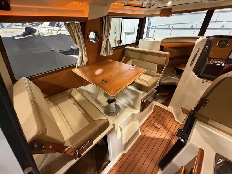 Slide: The Image of Interior of 2023 Ranger Tugs R 25 NW with wood table and leather seating. - 11