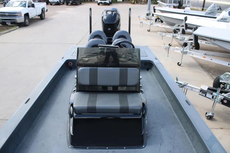 Slide: The Image of 2022 Majek 24 Reaper boat interior with seating and console, parked on a trailer. - 11