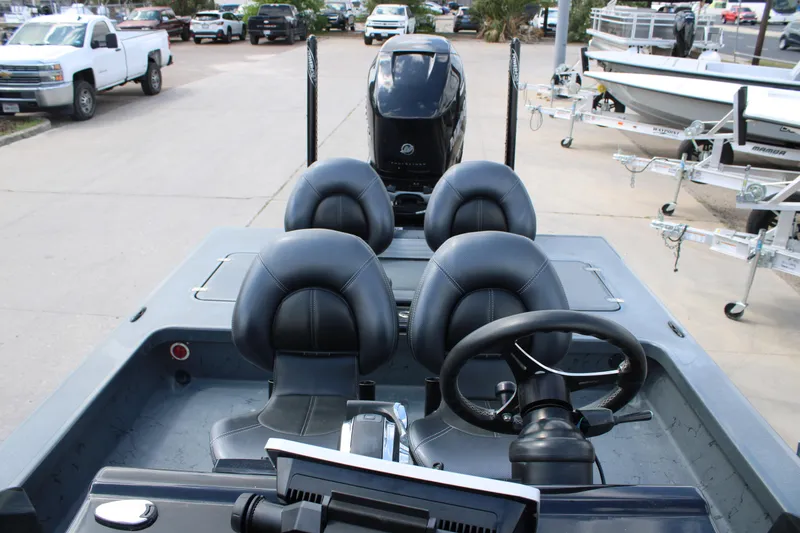 Slide: The Image of 2022 Majek 24 Reaper boat interior with steering wheel and seating, parked on a lot. - 12