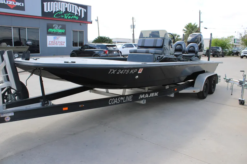 Slide: The Image of 2022 Majek 24 Reaper boat on trailer outside Waypoint Customs shop. - 2