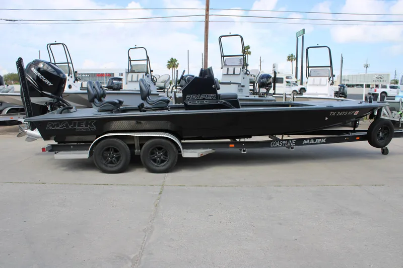 Slide: The Image of 2022 Majek 24 Reaper boat on trailer, featuring sleek black design and Mercury engine. - 3