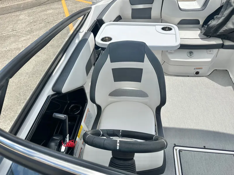 Slide: The Image of Interior of a 2022 Yamaha AR195 boat with steering and seating. - 18