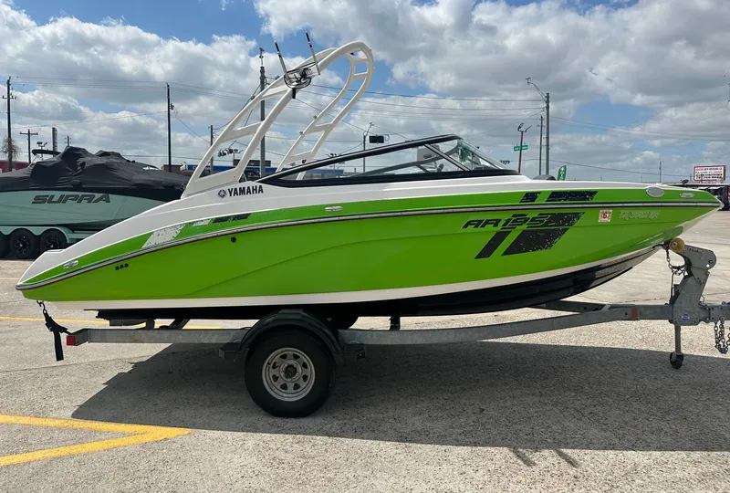 Slide: The Image of Green 2022 Yamaha AR195 boat on trailer under blue sky. - 3