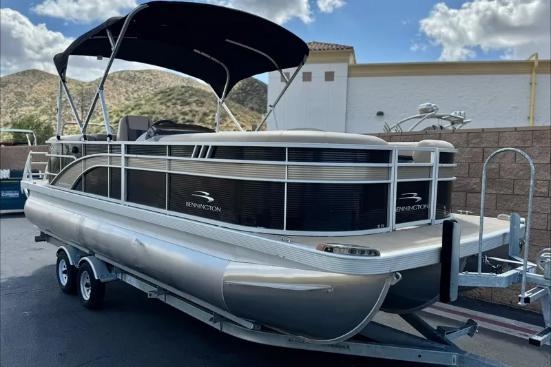 Slide: The Image of 2022 Bennington SX23 Salt Water Series pontoon boat on trailer, outdoor setting. - 1