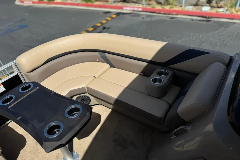 Slide: The Image of 2022 Bennington SX23 Salt Water Series boat interior with beige seating and cup holders. - 12