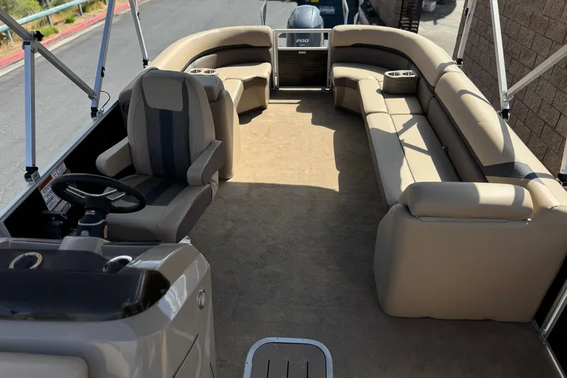 Slide: The Image of 2022 Bennington SX23 Salt Water Series pontoon boat interior with beige seating and steering console. - 16
