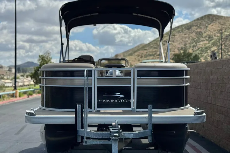 Slide: The Image of 2022 Bennington SX23 Salt Water Series pontoon boat on trailer, scenic mountain backdrop. - 2