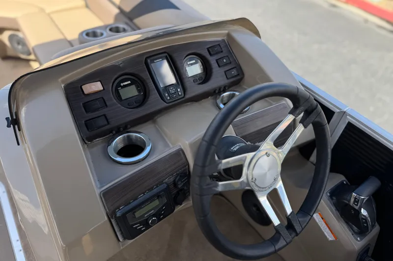 Slide: The Image of 2022 Bennington SX23 Salt Water Series boat dashboard with steering wheel and controls. - 24