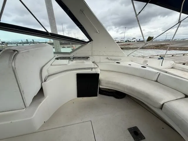 Slide: The Image of Interior of a 1993 Sea Ray 38 Express with white seating and window. - 8