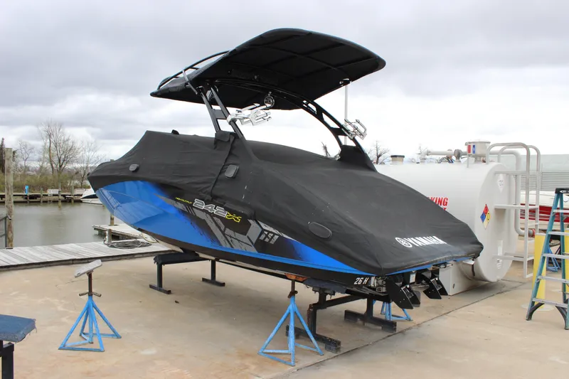Slide: The Image of 2017 Yamaha Boats 242 Limited S E-Series covered, elevated on stands by a dock. - 5