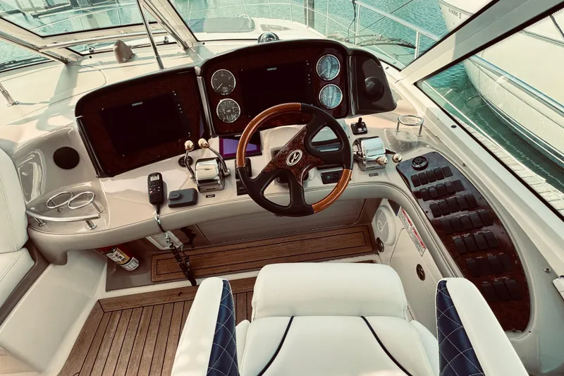 Slide: The Image of Cockpit of 2005 Sea Ray 500 Sundancer yacht with steering wheel and control panels. - 12
