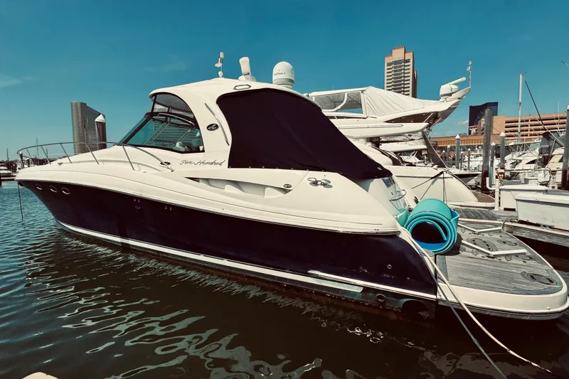 Slide: The Image of 2005 Sea Ray 500 Sundancer yacht docked in a marina under clear blue skies. - 2