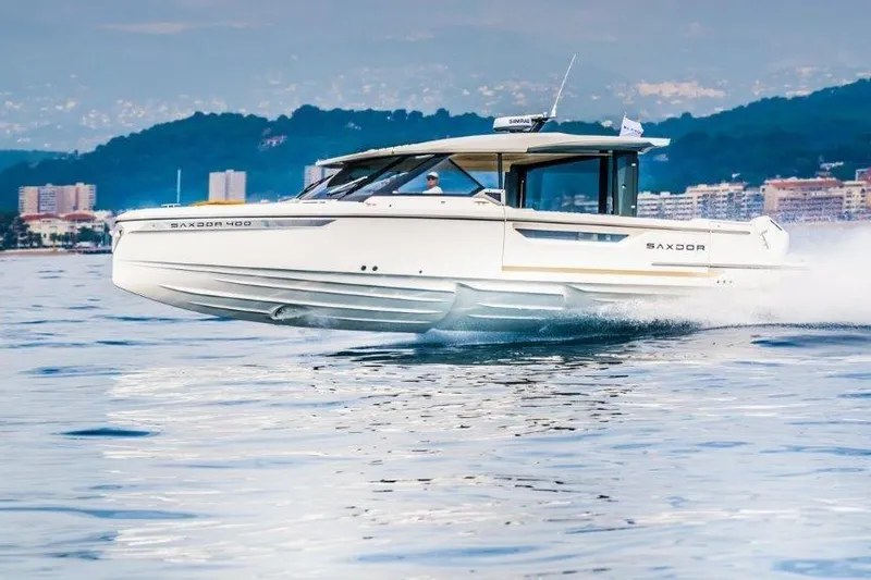 The Image of 2026 Saxdor 400 GTC cruising on calm waters near a coastal cityscape. - 1