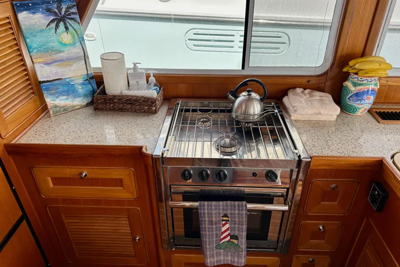 Slide: The Image of Helmsman Trawlers 38 Pilothouse 2016 galley with stove, kettle, and nautical decor. - 13