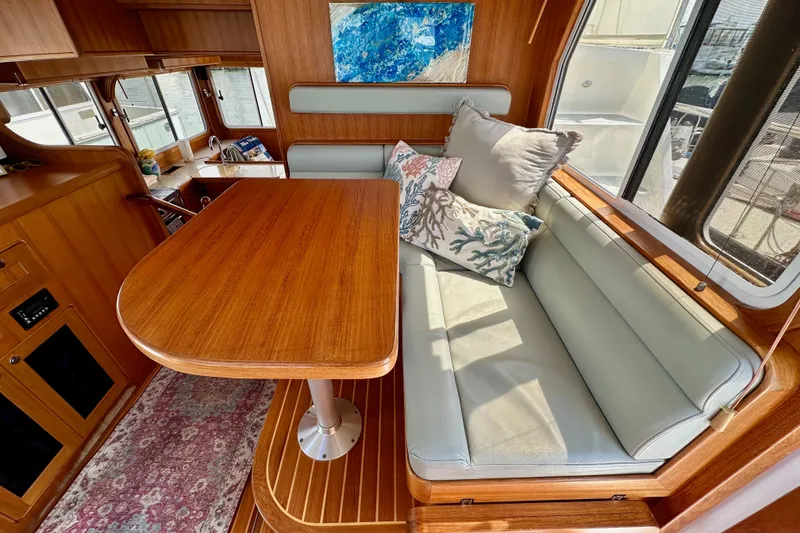 Slide: The Image of Interior of 2016 Helmsman Trawlers 38 Pilothouse with wooden table and cushioned seating. - 17