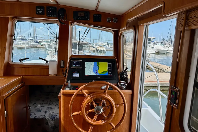 Slide: The Image of Helmsman Trawlers 38 Pilothouse 2016 interior with navigation equipment and marina view. - 19