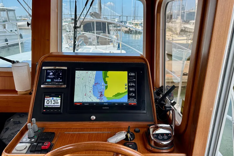 Slide: The Image of Helmsman Trawlers 38 Pilothouse 2016 dashboard with navigation system in marina setting. - 21