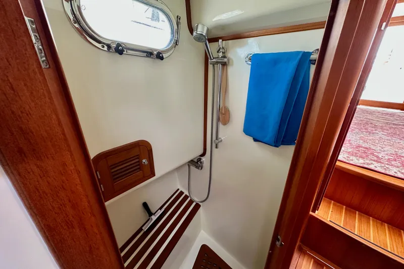 Slide: The Image of Shower area in 2016 Helmsman Trawlers 38 Pilothouse with wooden accents and blue towel. - 26